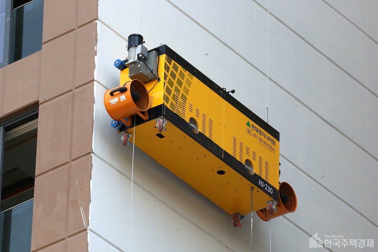 현대엔지니어링이 개발한 외벽도장로봇이 ‘힐스테이트 세운 센트럴’ 현장에서 파일럿테스트를 진행중이다. [사진=현대엔지니어링]