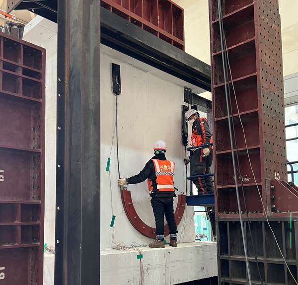 DL이앤씨 직원들이 수직증축 리모델링의 안전성 문제를 해결할 수 있는 ‘포스트텐션(Post-Tension) 하중전이공법’을 국내 건설업계 최초로 개발해 검증하고 있다. [사진=DL이앤씨 제공]