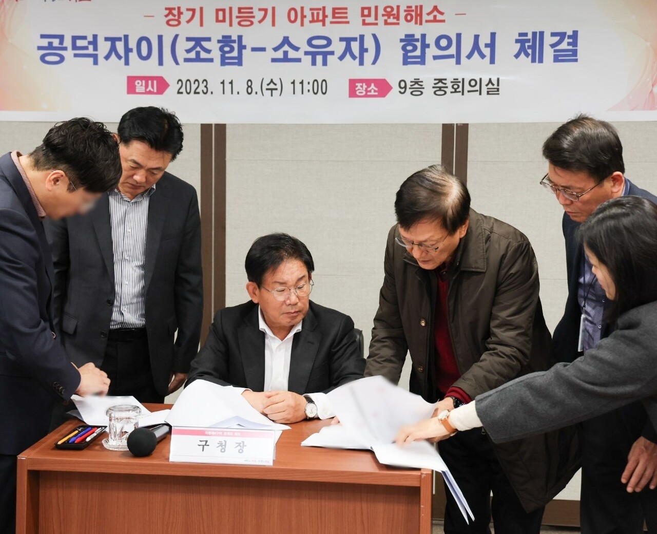 서울 마포구 공덕자이의 미등기 문제가 타개됐다. 박강수 구청장이 관계자들과 서류를 작성하고 있다. [사진=마포구 제공]