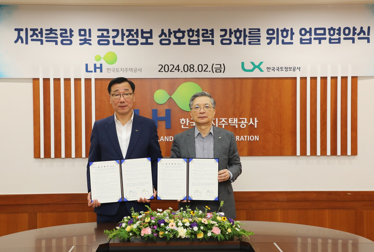 이한준 LH 사장(오른쪽)과 어명소 LX 사장(왼쪽)이 지적측량과 공간정보 분야 협력 강화를 위한 업무협약을 체결하고 기념사진을 촬영하고 있다. [사진=LH 제공]