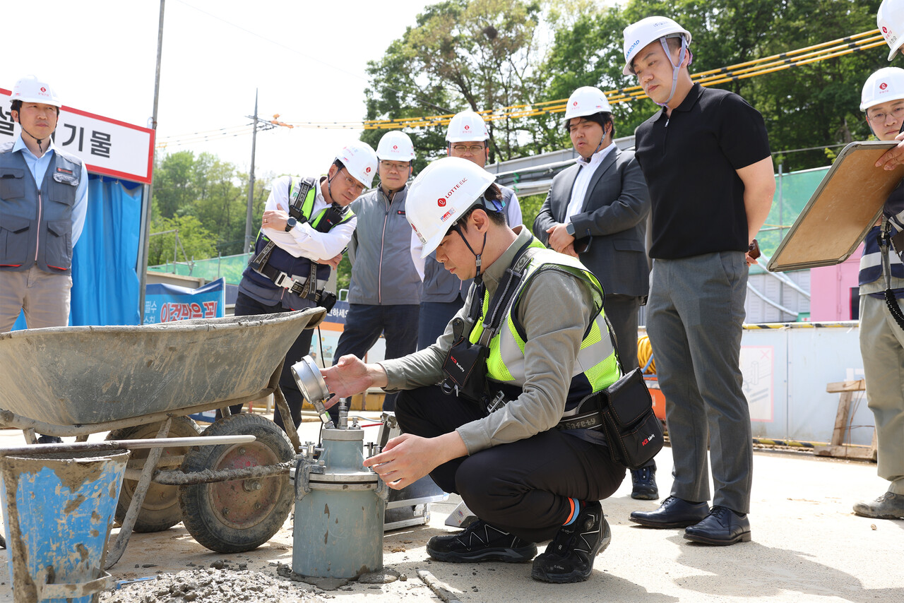 롯데건설 직원이 서초 헌인마을 현장에서 ‘차세대 혼화제’가 적용된 콘크리트를 테스트하고 있다. [사진=롯데건설 제공]