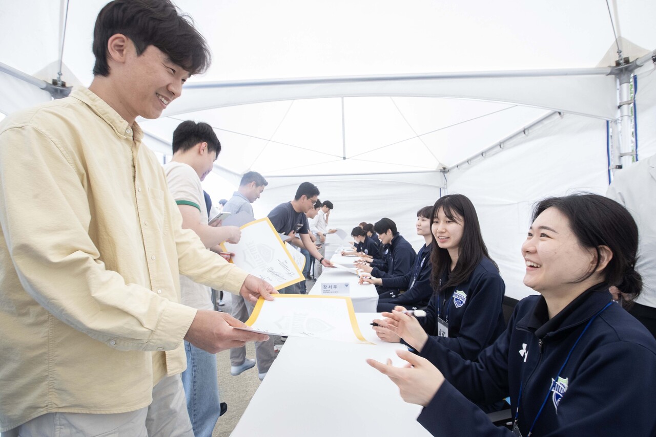 현대건설 배구단의 사인회 행사가 열려 임직원들이 평소 응원하던 선수들의 사인을 받고 응원 메시지를 전하기도 했다. 김연견 선수가 사인을 건네며 환하게 웃고 있다. [사진=현대건설 제공]