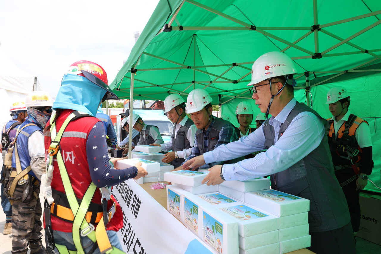 박현철 롯데건설 부회장(앞줄 오른쪽)이 대구 ‘타임빌라스 수성’ 현장에서 근로자들에게 아이스크림 츄러스와 이온음료, 혹서기 용품 등을 나눠주고 있다. [사진=롯데건설 제공]
