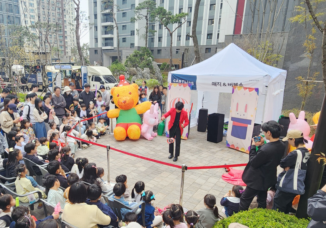 롯데캐슬 단지 입주민들이 마술쇼를 관람하고 있다. [사진=롯데건설 제공]