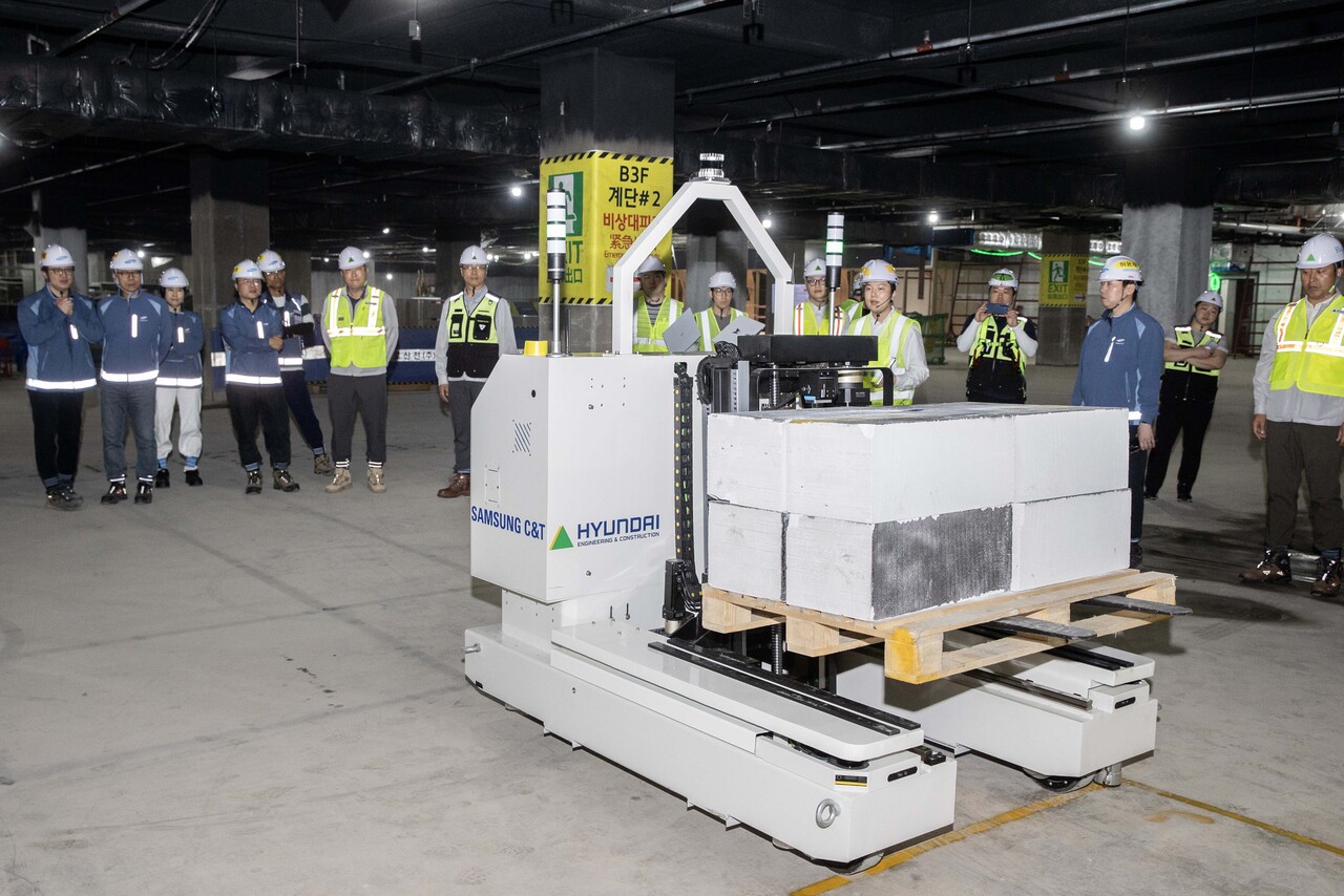 현대건설과 삼성물산이 공동 개발한 '스마트 자재 운반 로봇'이 현장에서 자재를 싣고 자율주행 이동하고 있다.  [사진=현대건설 제공]