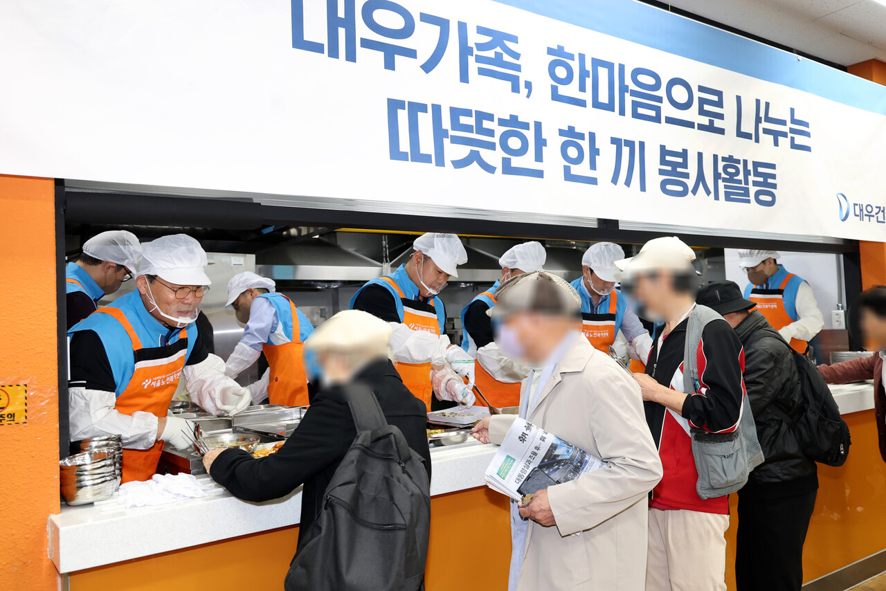 대우건설 김보현 대표이사(왼쪽)와 심상철 노동조합 위원장(오른쪽)이 무료 급식 봉사활동에 참여하고 있다. [사진=대우건설 제공]
