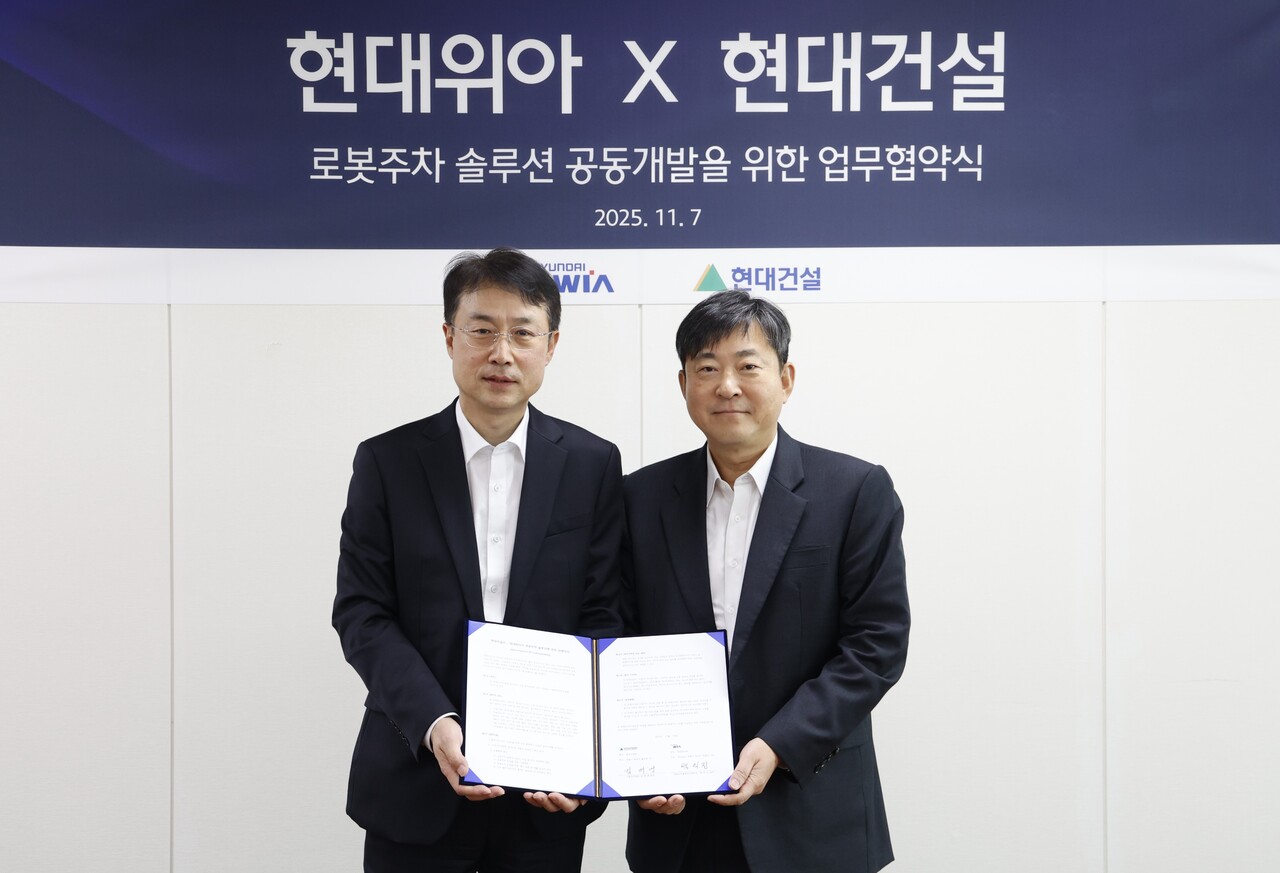 현대건설 기술연구원 김재영 원장(오른쪽)과 현대위아 모빌리티솔루션사업부 백익진 상무가 지난 7일 경기도 의왕시 현대위아 의왕연구소에서 열린 ‘로봇 친화형 주차솔루션 공동개발을 위한 업무협약식’에서 기념 사진을 찍고 있다. [사진=현대건설]